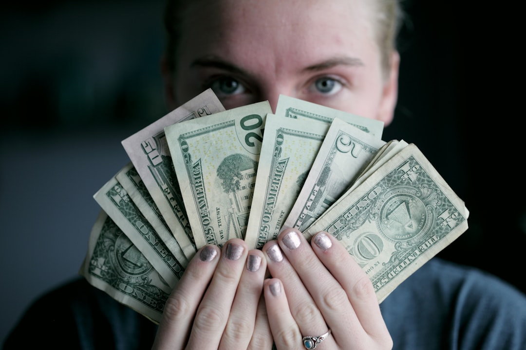 how to become millionier in 20 age - Young woman holding money.
