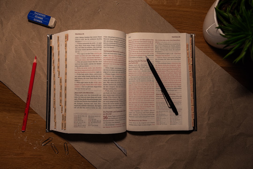 write about fake people and sins - An open book on a table with a pen and pencil