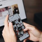 content marketing tips - A person is using their smartphone to browse the SumUp Instagram profile, focusing on posts related to marketing strategies and business tips. In the background, a laptop displays a webpage about tools for business growth, suggesting a workspace or content creation environment. This image highlights the use of social media for brand promotion, digital marketing, and business engagement, making it relevant for content creators, marketers, and entrepreneurs.