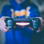 gaming tips and tricks - person holding black wireless controller