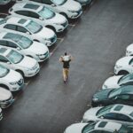 how to buy a car from dealership - a person standing in a parking lot