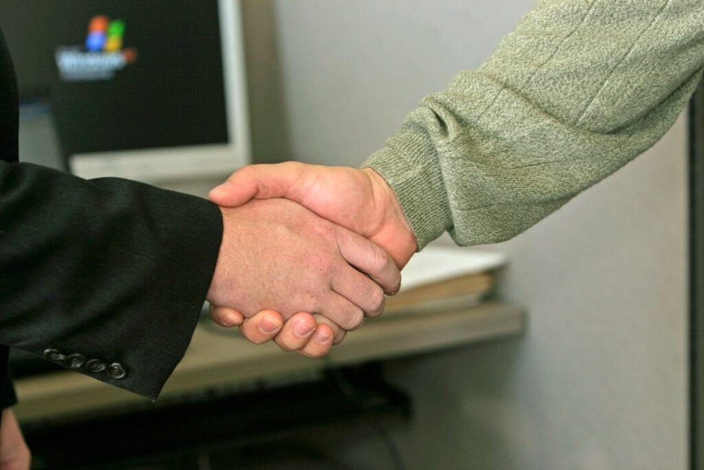 how to get a cra from dealership - two people shaking hands in front of a computer monitor
